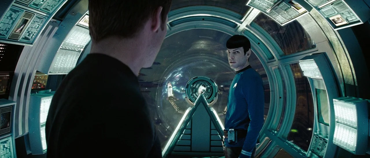 Star Trek (2009) movie still: medium — A curved futuristic spaceship tunnel features circular walls lined with glowing control panels. One man in a…