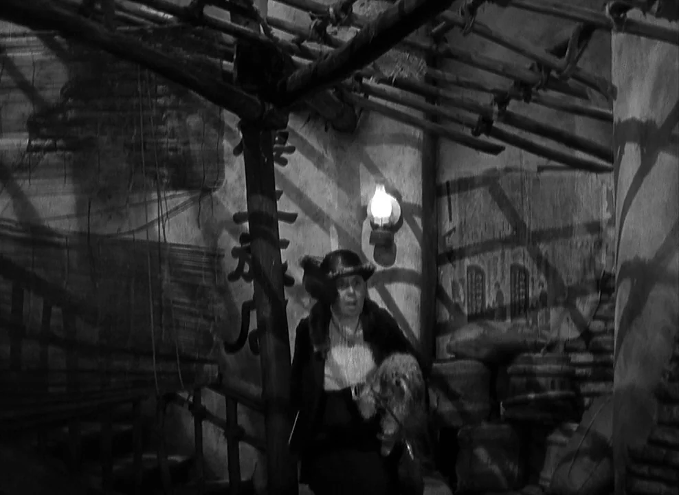 Shanghai Express (1932) movie still: medium — A cramped, dimly lit wooden interior features bamboo poles overhead and textured wall surfaces. A…