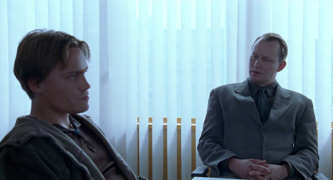 Insomnia (1997) movie still: medium — A modern meeting room features white vertical blinds covering the entire back wall. Two men sit in chairs…