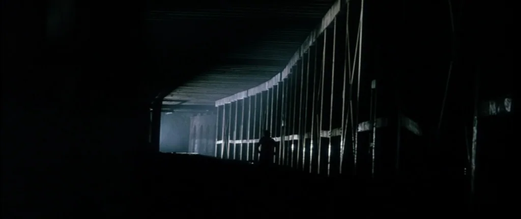 Bringing Out The Dead (1999) movie still: wide — A dark concrete underpass extends into the shadows with repetitive vertical support pillars. A…