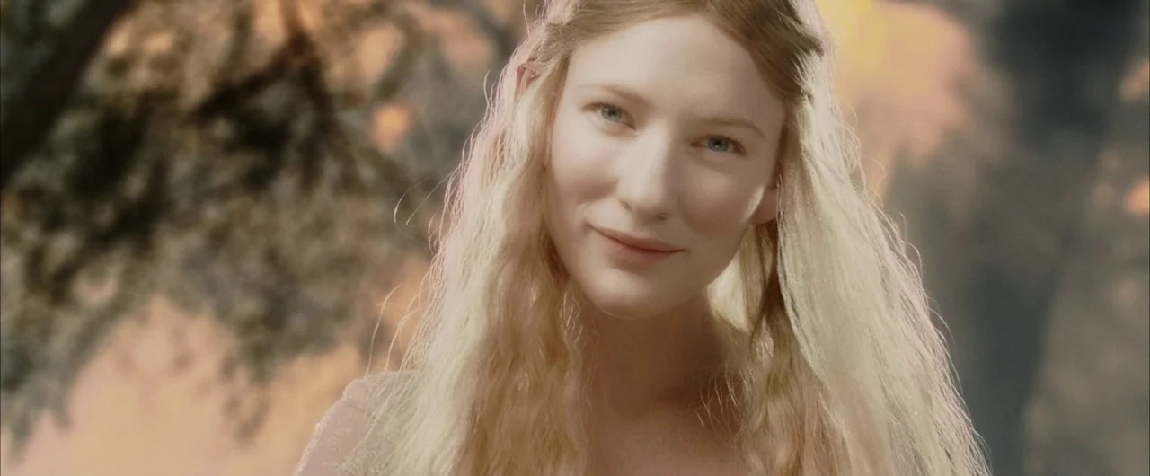 The Lord of The Rings: The Return of the King (2003) movie still: closeup — A figure stands in a sunlit woodland area with soft-focus trees in the…
