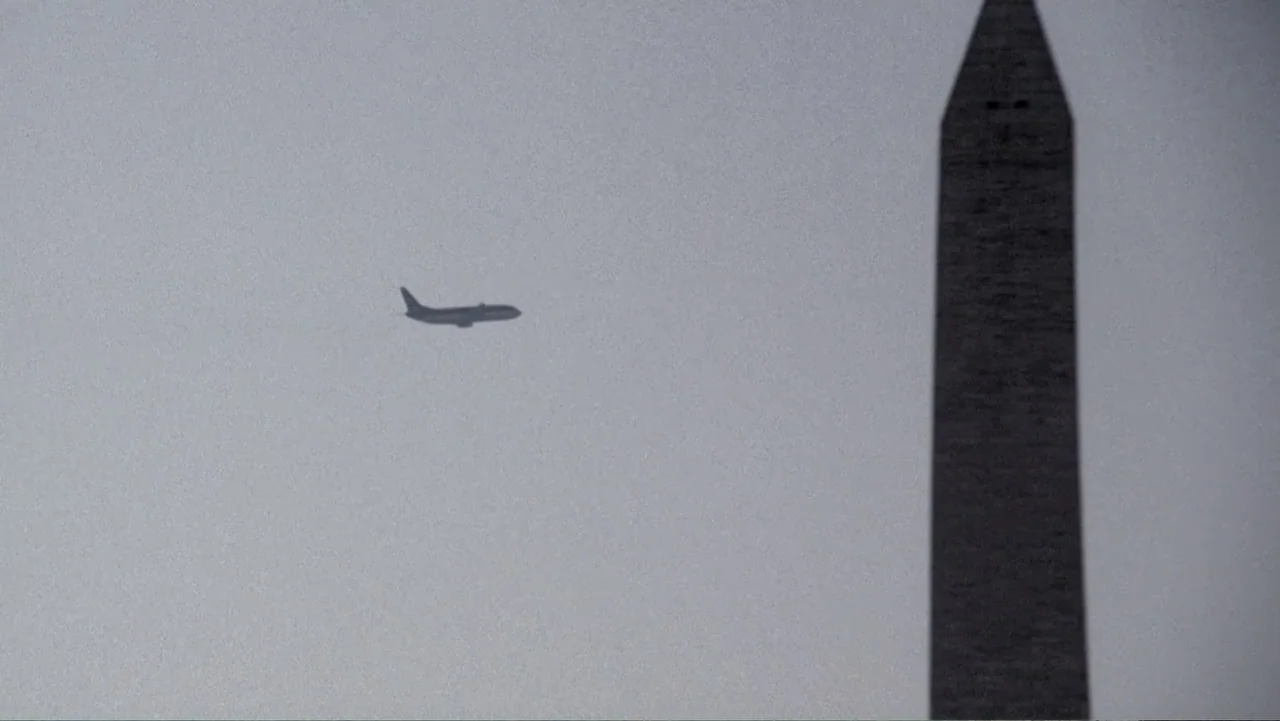 The Forever Prisoner (2021) movie still: establishing — An open sky scene features the Washington Monument against a flat grey overcast sky. A…