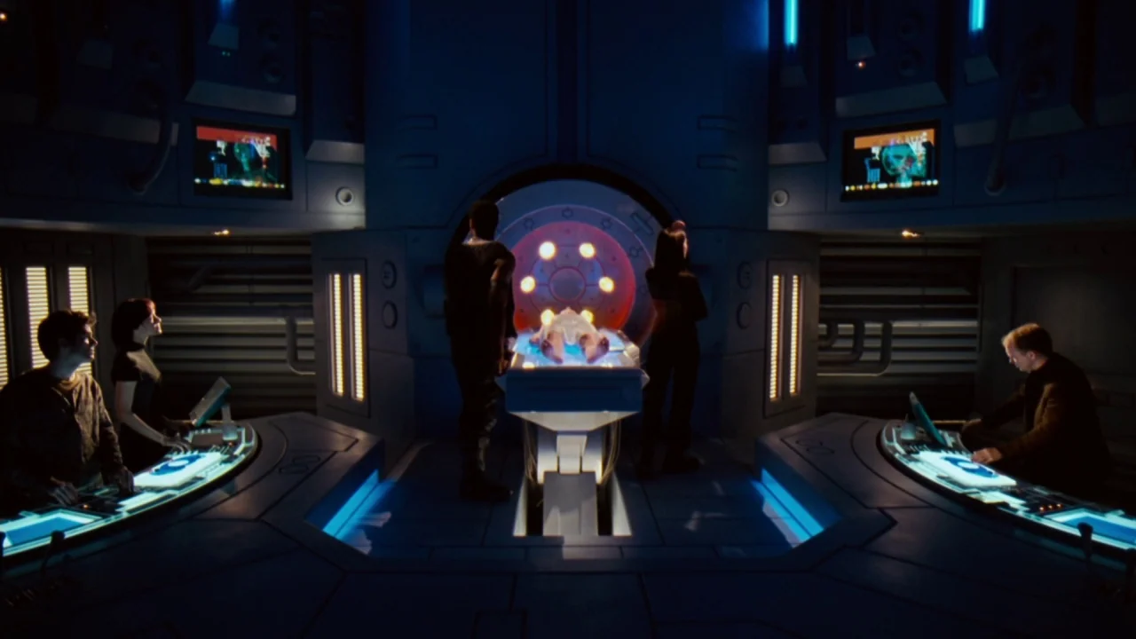 Jason X (2001) movie still: wide — A high-tech medical bay features a central circular pod surrounded by multiple computer consoles. Four people…