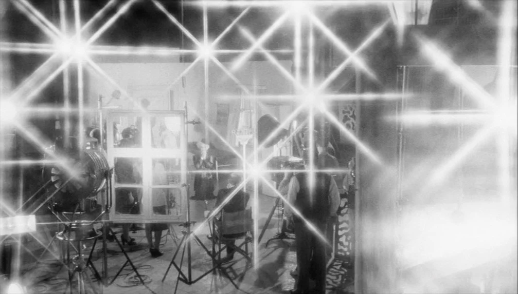 Veronika Voss (1982) movie still: wide — A film production set features various cameras, tripods, and lighting rigs on a floor. Several people are…