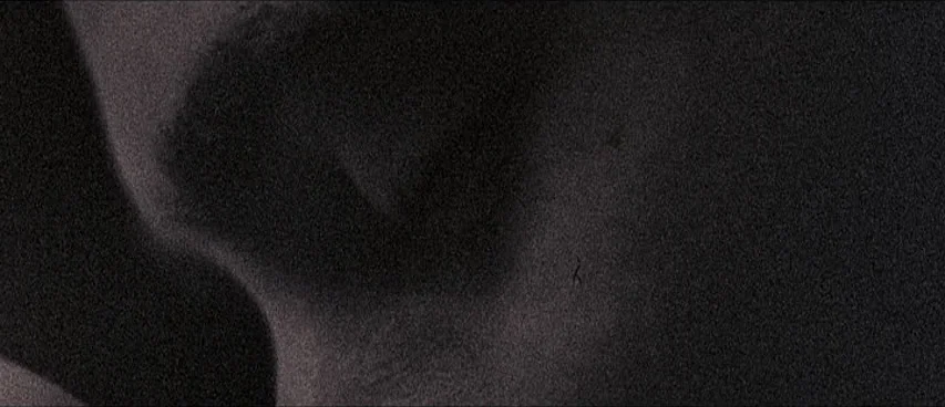 This Movie Is Broken (2010) movie still: closeup — An abstract close-up shot features grainy, low-contrast textures against a dark background. No…