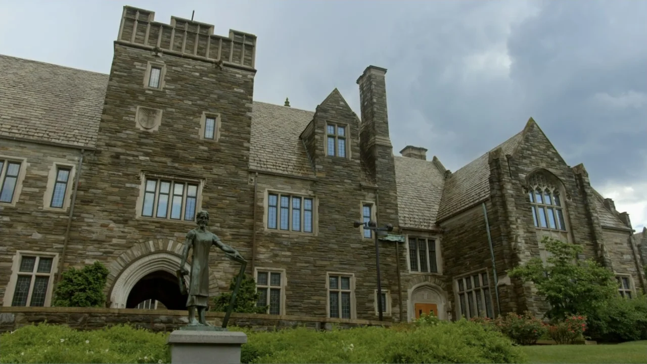 The Day the Music Died: The Story of Don McLean's "American Pie" (2022) movie still: establishing — A gothic stone building stands under a cloudy…