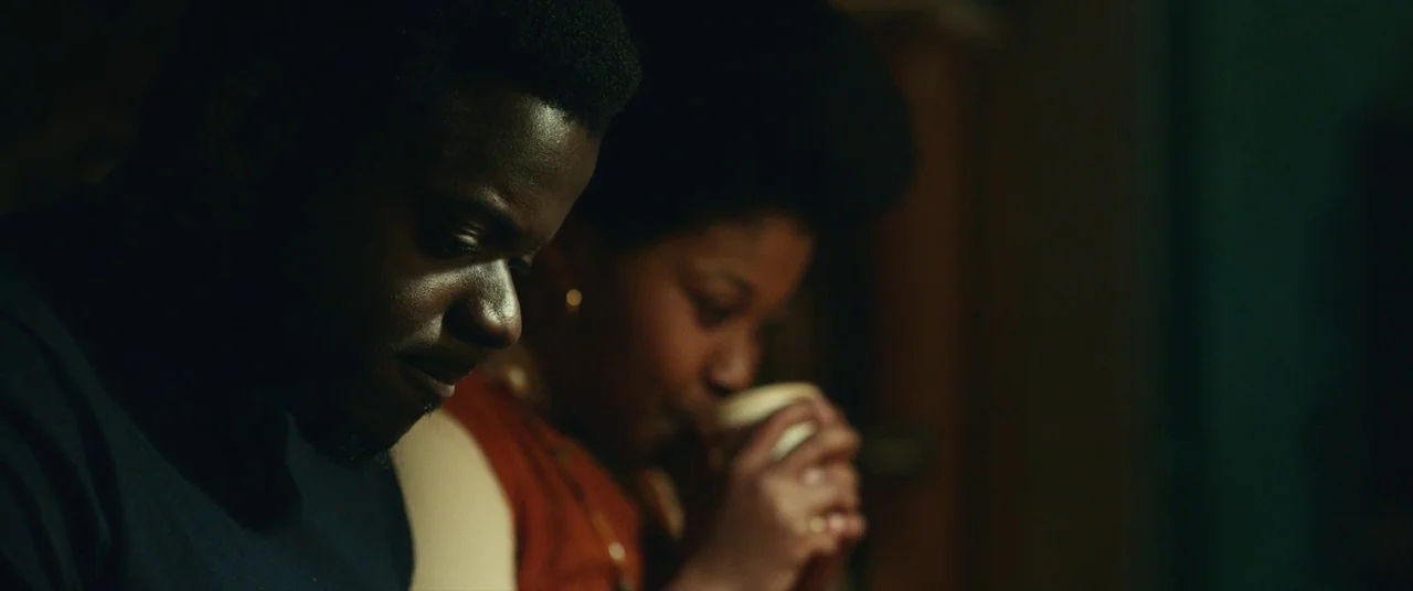 Judas and the Black Messiah (2021) movie still: medium — A dimly lit room with blurred background features that suggest a residential setting. A man…