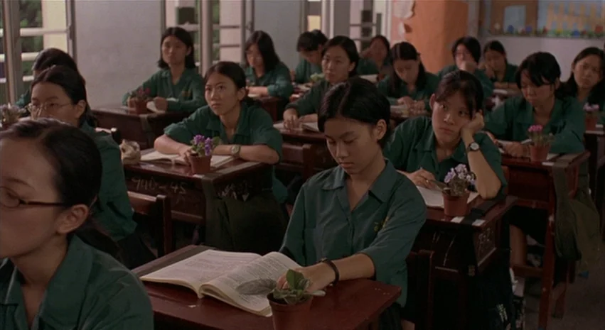 Yi-Yi (A One and A Two) (2000) movie still: medium — A school classroom is filled with students sitting at wooden desks in rows. The students wear…