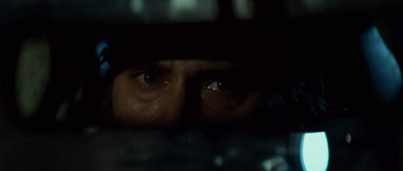 You Were Never Really Here (2017) movie still: closeup — A dark, constrained space inside a vehicle viewed through the frame of a mirror. A man's…