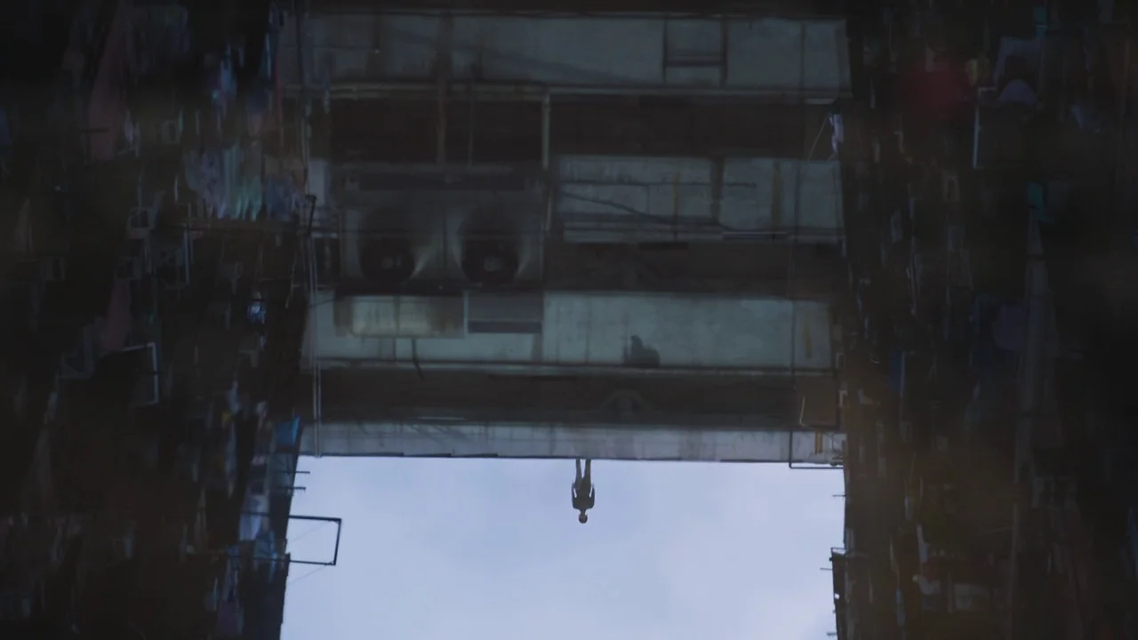 Ghost in the Shell (2017) movie still: wide — A dense urban residential structure with multiple levels and air conditioning units. A lone figure…
