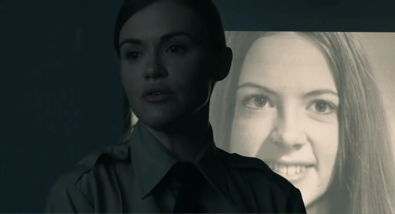 Ted Bundy: American Boogeyman (2021) movie still: medium — An interior office at night features a woman in a dark green uniform. A large black and…