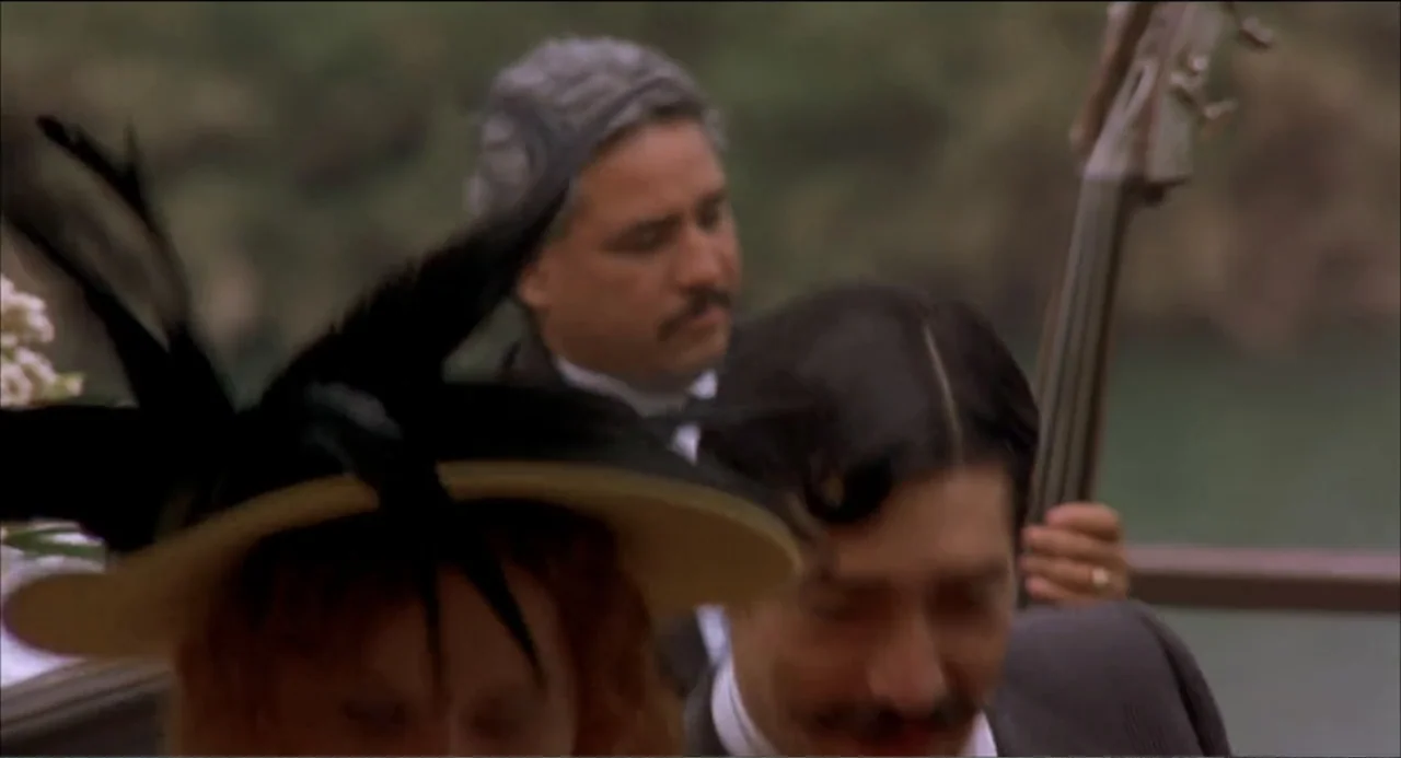 Like Water for Chocolate (1992) movie still: medium — Three people stand closely together on an outdoor deck with natural greenery visible behind. A…