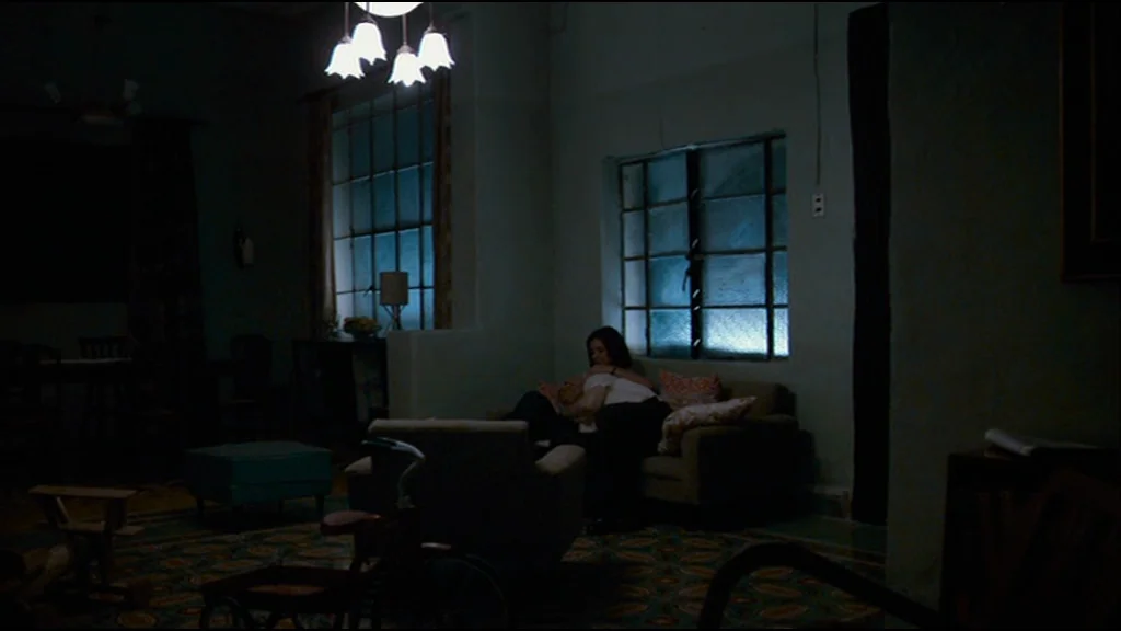 Che Part 2 (Guerrilla) (2008) movie still: wide — A dark, sparsely furnished room features patterned floor tiles and large rectangular window panes.…