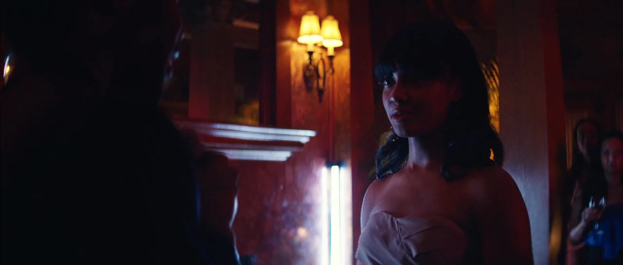 Magic Mike XXL (2015) movie still: medium — A dimly lit club with red-toned walls featuring traditional wall sconces and vertical lighting. A young…