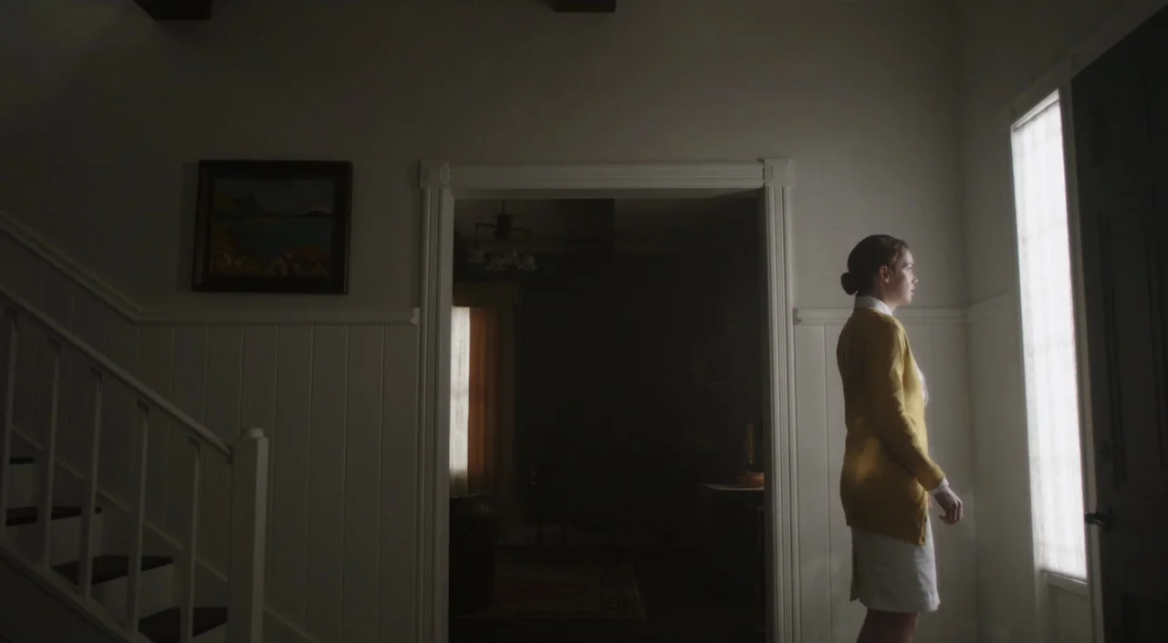 I Am The Pretty Thing That Lives In The House (2016) movie still: medium — A dimly lit hallway features a staircase to the left and a doorway to…
