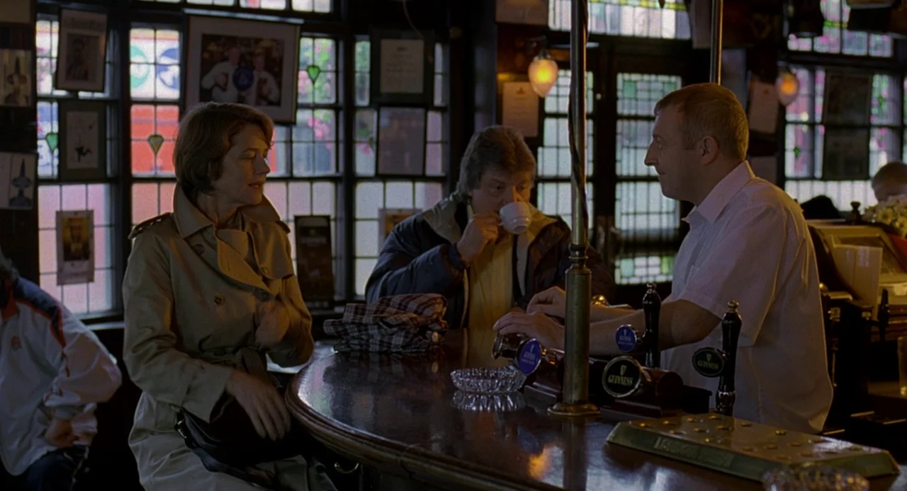 Swimming Pool (2003) movie still: medium — A traditional wood-paneled establishment with leaded glass windows and framed pictures on the wall. A…