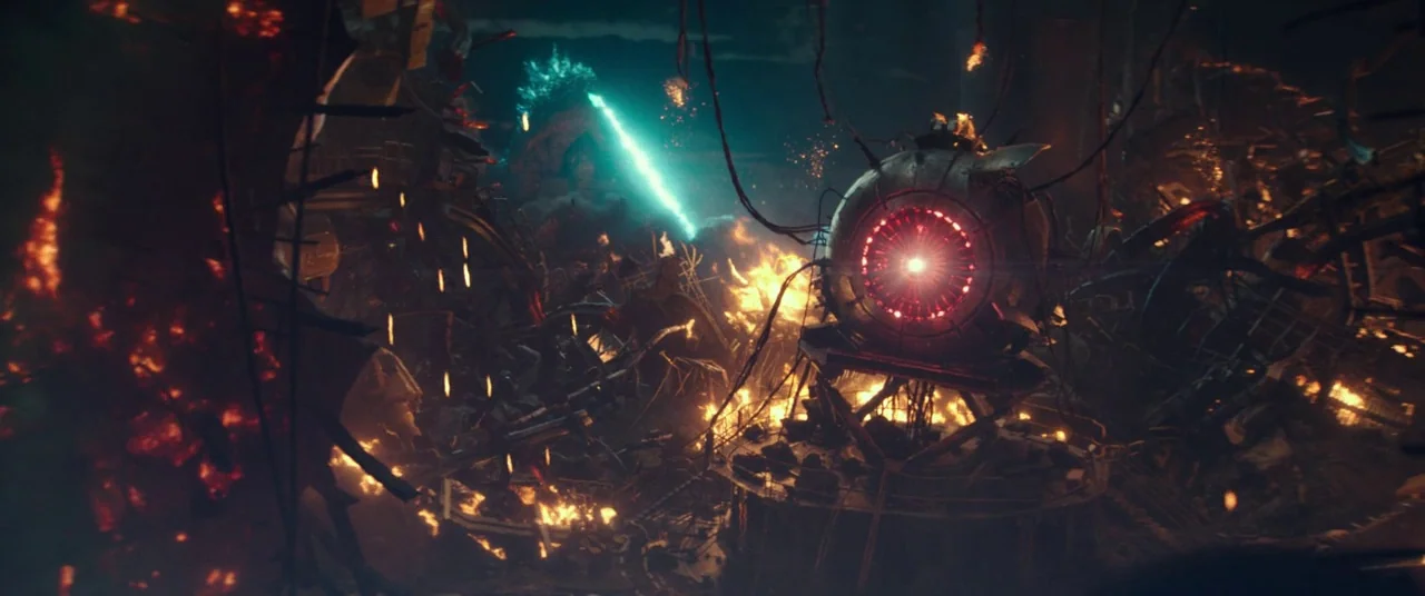 Godzilla Vs. Kong (2021) movie still: wide — A dark, war-torn battlefield is filled with debris and burning piles of rubble. A large metallic orb…
