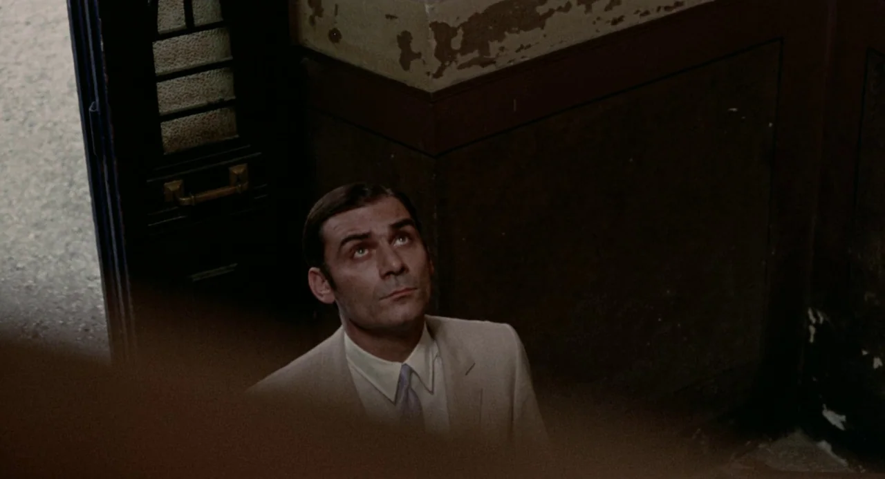 Investigation of a Citizen Above Suspicion (1970) movie still: medium — A stairwell features dark wall panels topped with weathered, peeling…