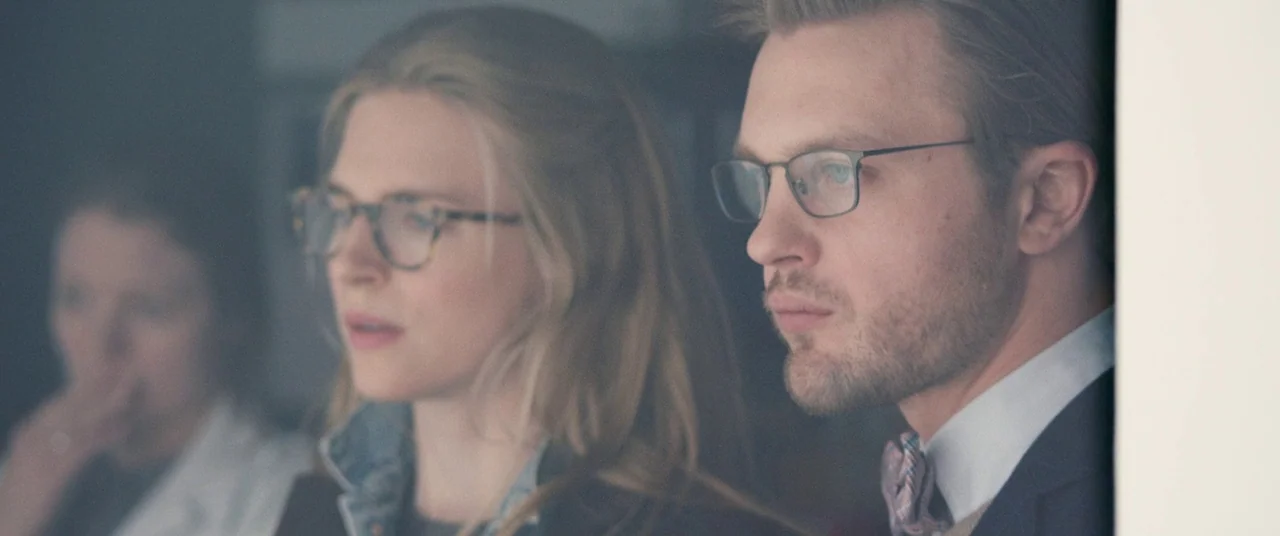 I Origins (2014) movie still: medium — A modern indoor workspace with bright, indirect light filtering through a large window. A man in a suit and a…