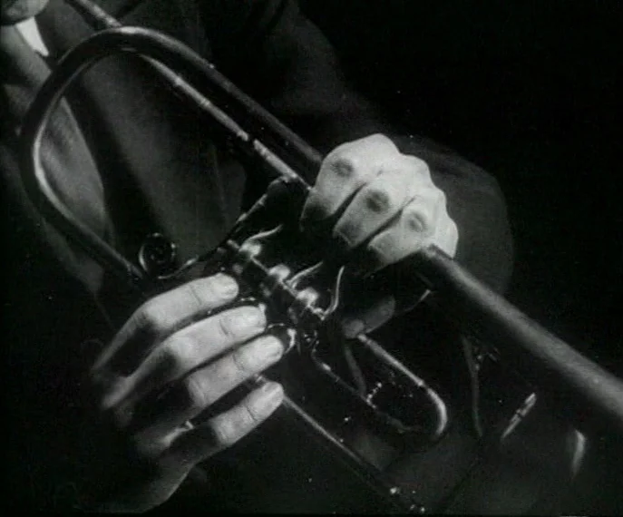 Man with a Movie Camera (1929) movie still: closeup — Close view of a musician's hands resting on the valves of a trumpet. The brass instrument…