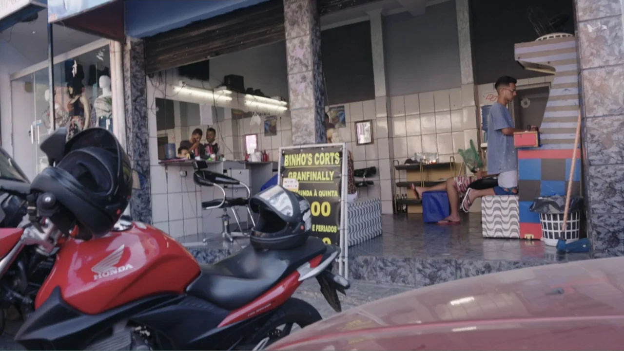 Finding the Way Home (1991) movie still: medium — A street-level barbershop features tiled walls and a small gaming area near the entrance. A young…