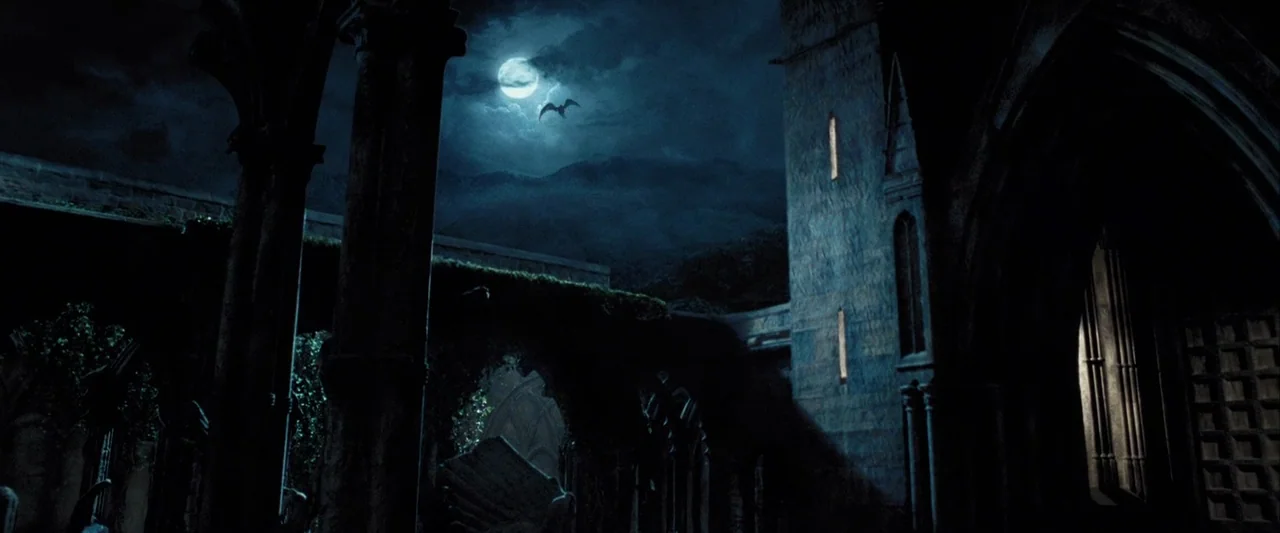 Harry Potter and the Prisoner of Azkaban (2004) movie still: establishing — An ancient stone courtyard features gothic arches covered in creeping…