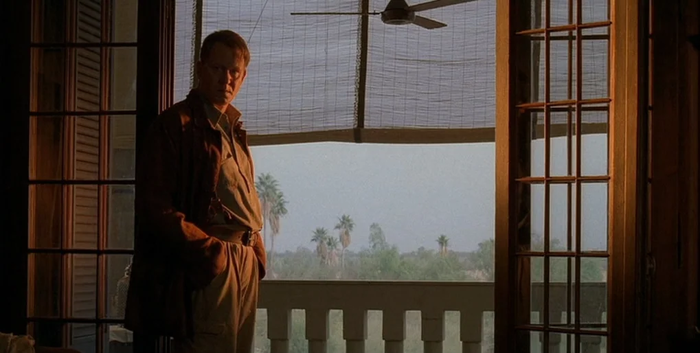 Dominion: Prequel to the Exorcist (2005) movie still: medium — A man stands inside a room beside a large open window with a balcony. Beyond the…