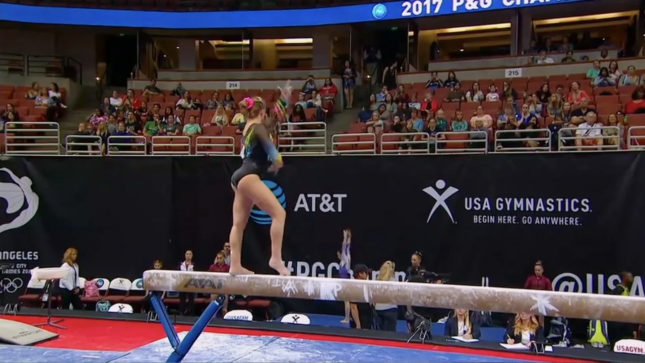 At the Heart of Gold: Inside the USA Gymnastics Scandal (2019) movie still: fullbody — A large indoor sports arena with red stadium seating filled…