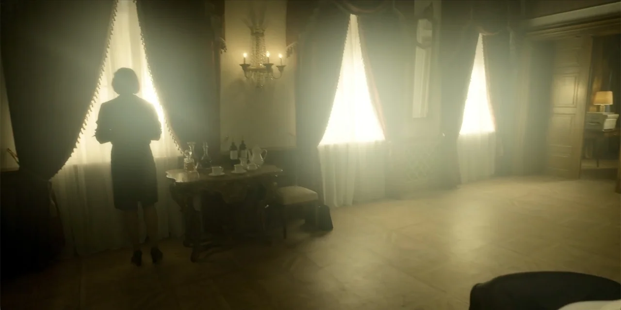 Oslo (2021) movie still: fullbody — A vintage hotel room features heavy curtains, wood paneling, and an ornate side table. A woman in a dark dress…
