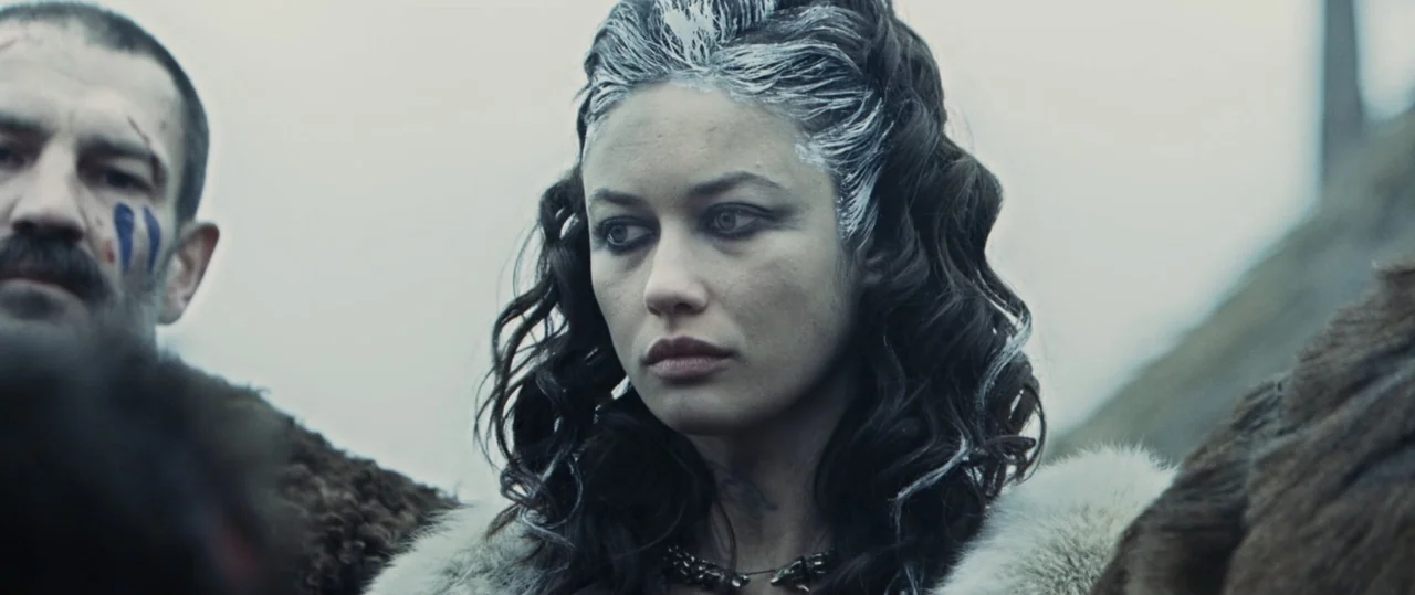 Centurion (2010) movie still: medium — An outdoor hillside setting under a grey overcast sky features two people dressed in furs. A woman and a man…