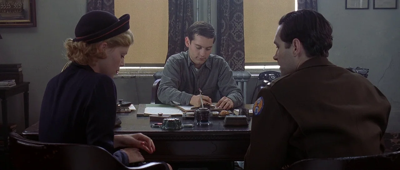 The Cider House Rules movie still: medium — A 1940s style office features two windows with patterned curtains and a large desk. A man in a work…