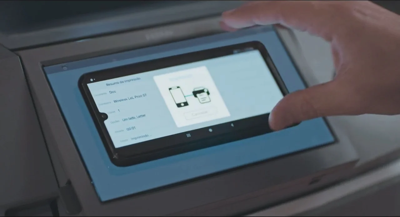 Proof of Love (2022) movie still: closeup — The control panel of an office multifunction printer displays a wireless printing progress menu. A human…