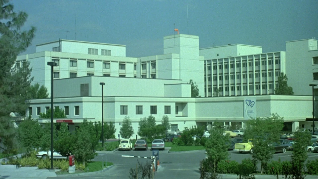 Bride of Reanimator (1989) movie still: establishing — A sprawling white multistory hospital building complex sits amidst landscaped greenery and…