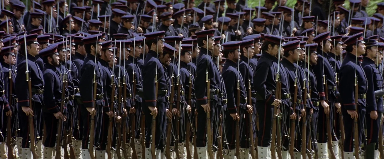 The Last Samurai (2003) movie still: wide — A vast formation of nineteenth-century soldiers stands in disciplined ranks outdoors. Each man holds a…