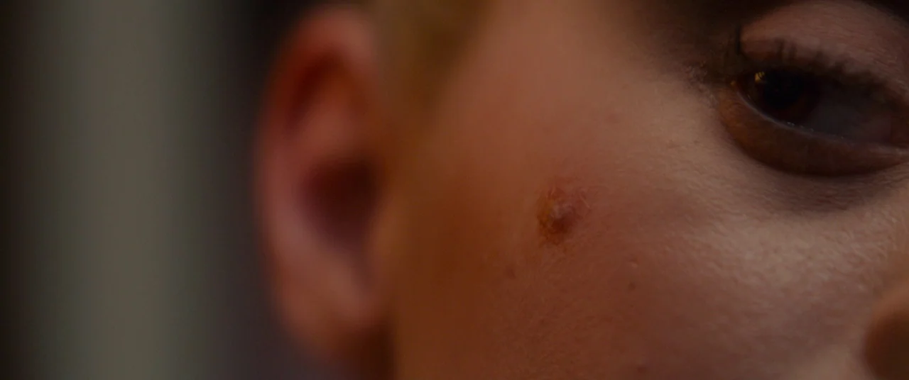 Scary Stories to Tell in the Dark (2019) movie still: closeup — A close-up view of a person's face showing an ear and one eye. The skin texture is…