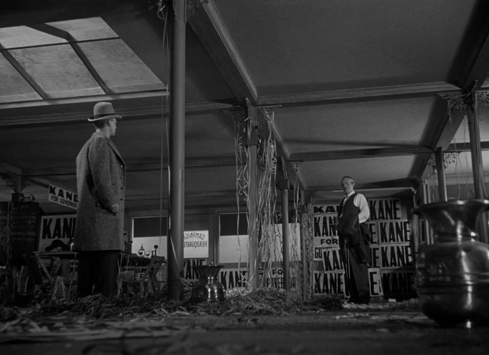 Citizen Kane (1941) movie still: wide — A campaign headquarters filled with discarded paper streamers and numerous political posters on walls. Two…