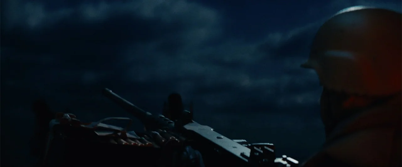 Battleship (2012) movie still: medium — A dark night on a military front with heavy clouds covering the sky above. A soldier wearing a helmet looks…