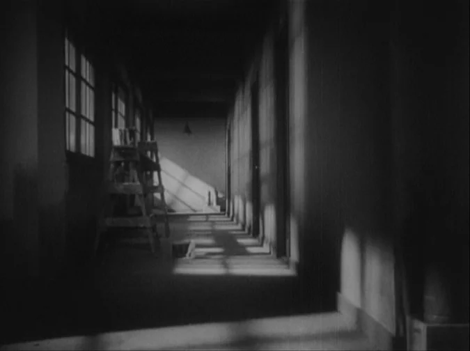 Drunken Angel (1948) movie still: establishing — A long, narrow school hallway features rows of windows casting sharp diagonal shadows inside. An…