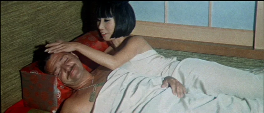 MASH (1970) movie still: medium — A Japanese-style room features a shoji screen partition and straw-textured wall coverings. A woman gently touches…