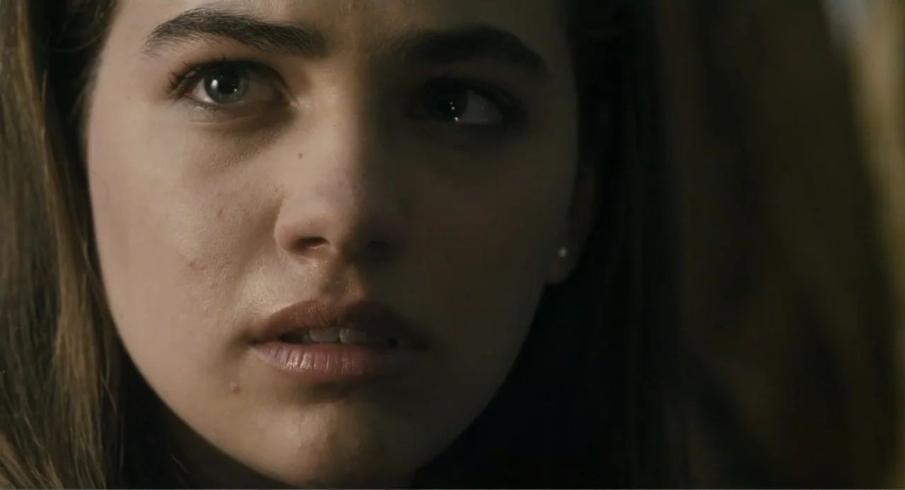 Gates of Darkness (2019) movie still: closeup — An indoor space with soft ambient light filtering onto the subject's face. A young woman turns her…