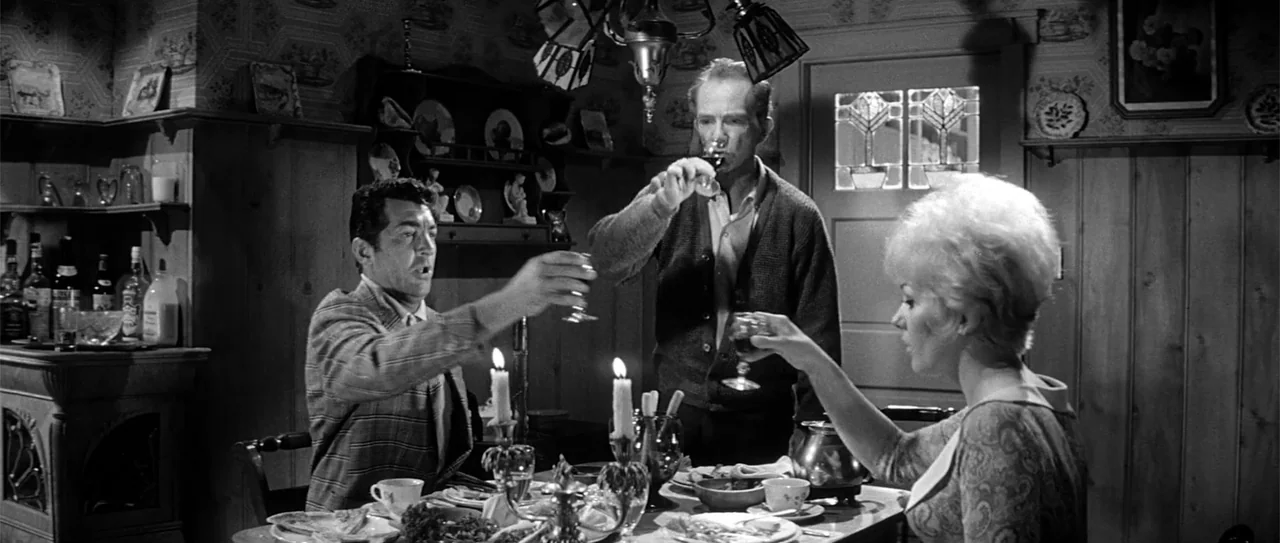 Kiss Me, Stupid (1964) movie still: medium — A furnished interior dining space with wood paneling and decorative plates on the wall. Three people…
