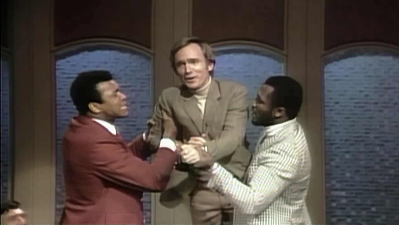 Ali & Cavett: The Tale of the Tapes (2018) movie still: medium — A television studio set features arched windows with brick-textured backdrops…