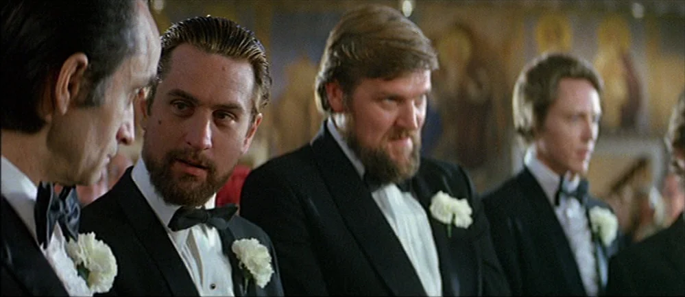 The Deer Hunter (1978) movie still: medium — A church interior with large religious icon paintings visible on the back wall. Several men in matching…