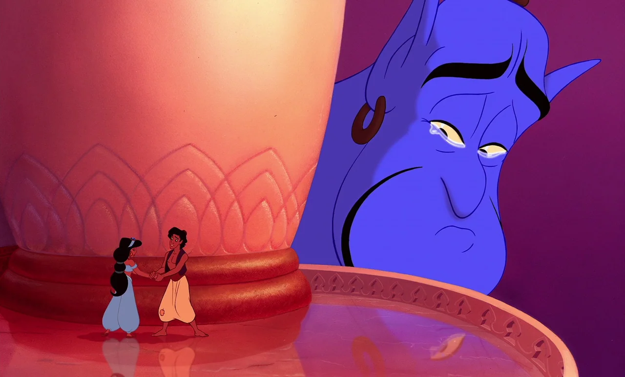 Aladdin (1992) movie still: wide — A large interior space features a giant architectural column and a circular fountain pool. Two small human…