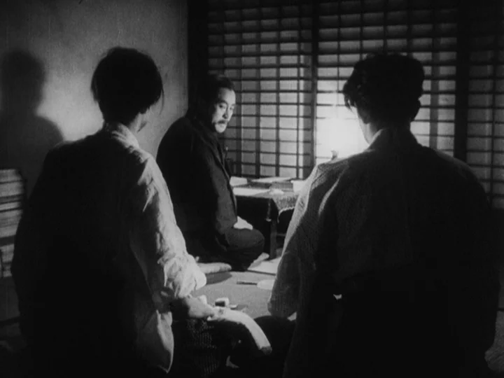 Sanshiro Sugata (1943) movie still: medium — A traditional Japanese room features shoji paper screens and tatami floor mats. Three people sit on the…