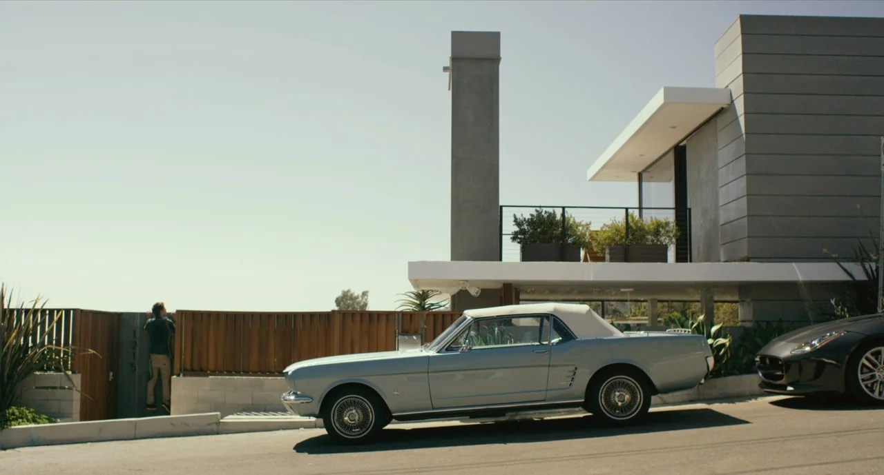 We Are Your Friends (2015) movie still: wide — A man stands near a modern multi-level residence with a wood-slatted gate. A vintage light-blue…