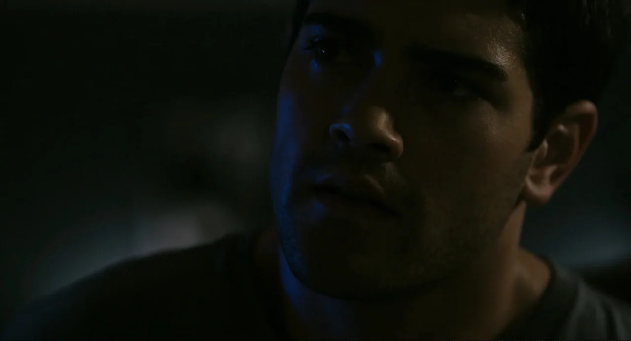 Beyond a Reasonable Doubt (2009) movie still: closeup — A dimly lit room with dark surroundings obscuring architectural details. A young man stares…