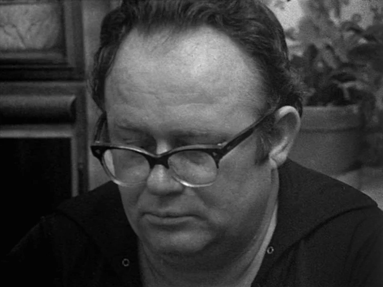 Family Nest (1979) movie still: closeup — A close portrait of a man in an interior domestic setting. The man sits with his eyes closed and wears…
