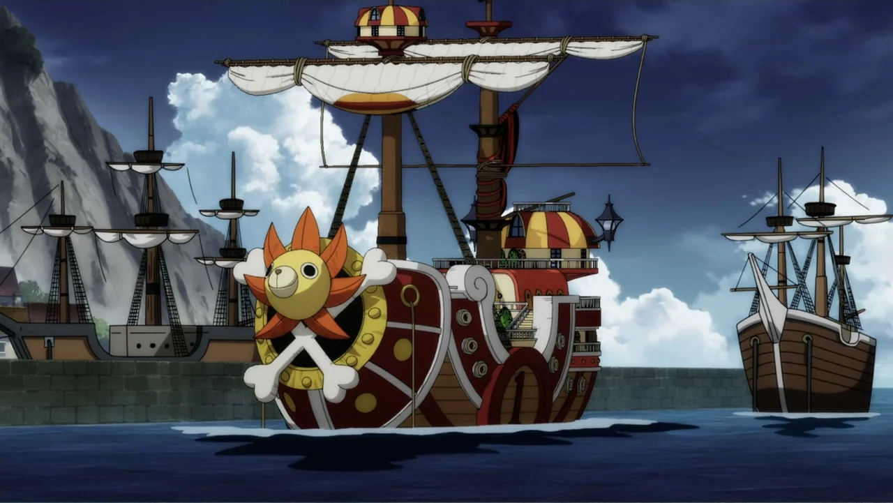 One Piece Film Red (2022) movie still: wide — A cartoon harbor setting features three wooden sailing ships moored against a stone pier. The central…