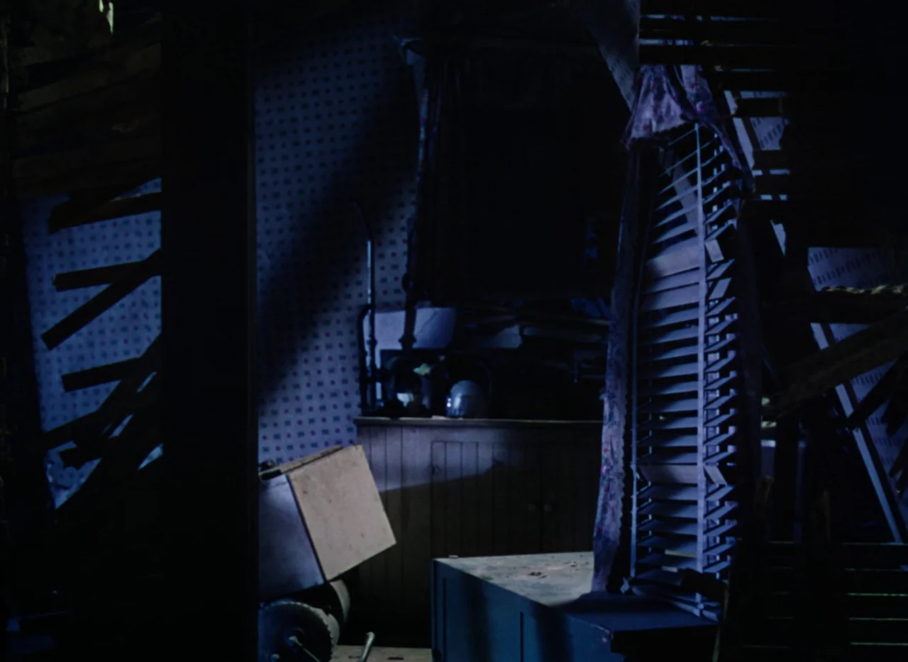 The War of the Worlds (1953) movie still: establishing — A dark, decaying interior space features peeling wallpaper and broken wooden structural…